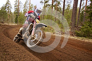 Motocross driver accelerating the motorbike on the race track