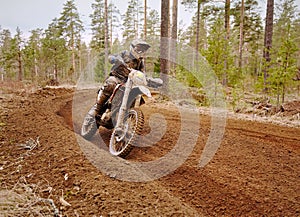 Motocross driver accelerating the motorbike on the race track