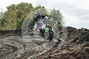 Motocross driver on race track