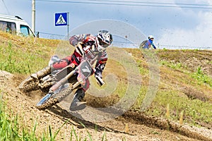 Motocross. Motorcyclist in a bend rushes along a dirt road, dirt flies from under the wheels.