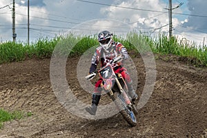 Motocross. Motorcyclist in a bend rushes along a dirt road, dirt flies from under the wheels.