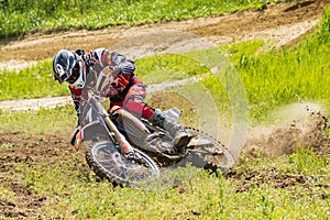 Motocross. Motorcyclist in a bend rushes along a dirt road, dirt flies from under the wheels. Close-up.