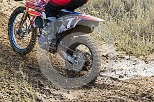 Motocross. Motorcyclist rushes along a dirt road, dirt flies from under the wheels.