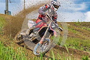 Motocross. Motorcyclist rushes along a dirt road, dirt flies from under the wheels.