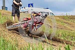 Motocross. Motorcyclist rushes along a dirt road, dirt flies from under the wheels. Photographers near. Doctors are watching.