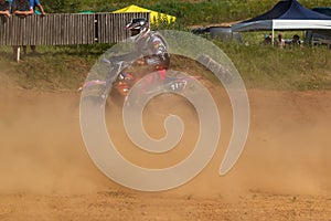 Motocross. Motorcyclist rushes along a dirt road, dust flies from under the wheels.