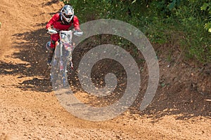 Motocross. Motorcyclist rushes along a dirt road, dust flies from under the wheels.