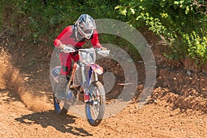 Motocross. Motorcyclist rushes along a dirt road, dust flies from under the wheels.