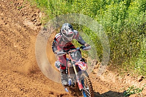 Motocross. Motorcyclist rushes along a dirt road, dust flies from under the wheels.