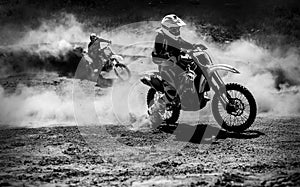 Motocross racer accelerating in dust track, Black and white photo