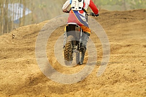 Motocross racer accelerating speed in track