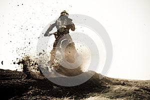 Motocross racer roosts dirt berm on track.