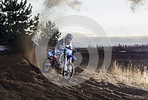 Motocross rider creates a cloud of dust and debris