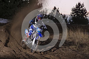 Motocross rider creates a cloud of dust and debris