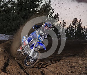 Motocross rider creates a cloud of dust and debris