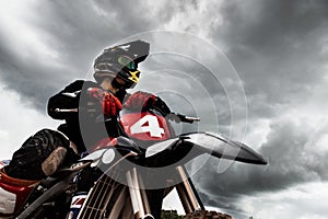 Motocross rider on his bike ready to race in dirt track