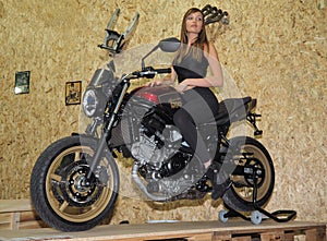 Verona, Italy - january 20, 2018: motor bike expo, a blonde hostess posing on motorbike. Verona, Veneto, Italy