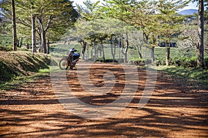 Motor bike parked on a red dirt road