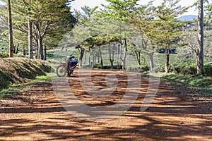 Motor bike parked on a red dirt road