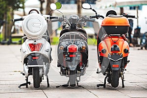 Motor Bikes for rent. Rear view on three different scooter bike on rent parking