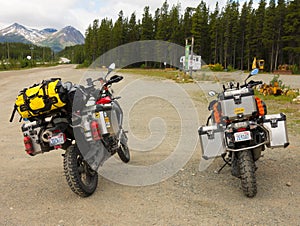 Motor bikes well equipped for a road trip parked at a rest area in northern canada