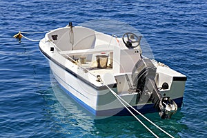 A motor boat is anchored in the clear waters of the Ionian Sea