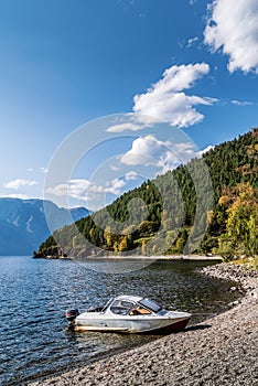 Motor boat moored to the shore of a mountain lake photo