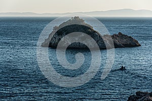 Motor Boat towards the small island in blue Ionian Sea