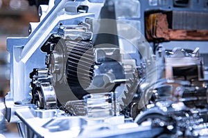 Motor of the electric car with powertrain and power connections closeup. Blue toned. EV car at maintenance