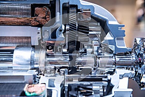 Motor of the electric car with powertrain and power connections closeup. Blue toned. EV car at maintenance photo