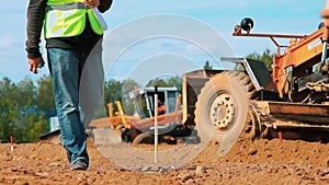 Motor grader leveling ground on construction site. Dirty heavy machinery working