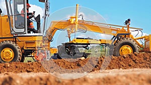 Motor grader leveling ground. Construction site machinery