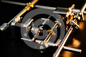 motor and guides for the laser machine. details of the engraving machine, black warm background, orange light photo