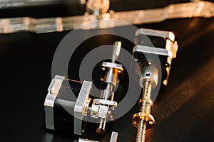 Motor and guides for the laser machine. details of the engraving machine, black warm background, orange light photo