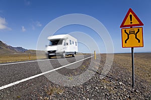 Motor Home Driving On Road With Danger Sign