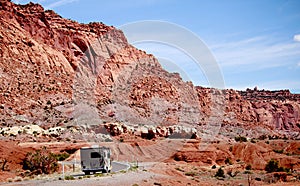 Motor home RV traveling through red rocks in Utah.