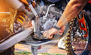 Motor mechanic working on motorcycle mx engine in mechanics garage. Repair service. authentic close-up shot