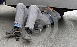Motor mechanic works on the exhaust pipe