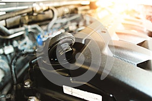 Motor oil cap of the automotive engine on plastic cover in the engine compartment
