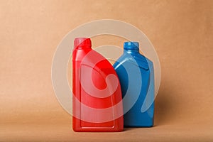 Motor oil in different canisters on light brown background