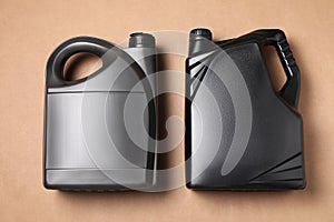 Motor oil in different canisters on light brown background, flat lay