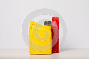 Motor oil in different canisters on table against white background