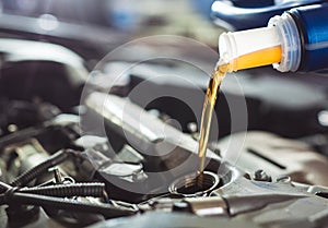 Motor oil pouring to car engine. Repair service.