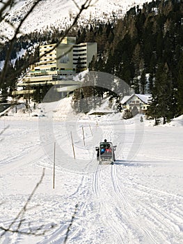 Motor sled moving towards a hotel on a frozen lake at Turracher Hohe