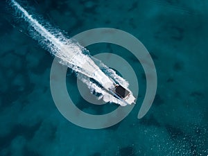 Motor speedboat moving on crystal emerald sea water. Above drone view