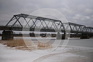 motor transport pedestrian bridge over the Luga river in winter cloudy time photo