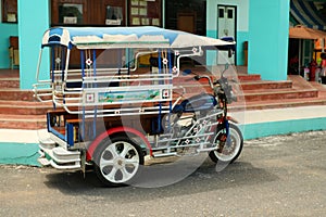 Motor tricycle car before a vintage movie theater