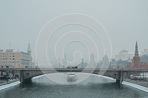 A motor vessel sails under the Bolshoi Moskvoretsky Bridge near the Moscow Kremlin