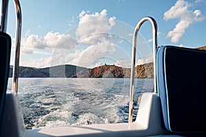 Motor yacht cruising in the sea, view from the stern