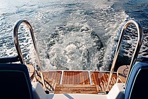 Motor yacht cruising in the sea, view from the stern